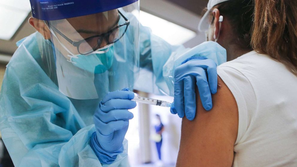 PHOTO: A nurse administers a flu vaccination shot to a woman at a free clinic, Oct. 14, 2020, in Lakewood, Calif. 