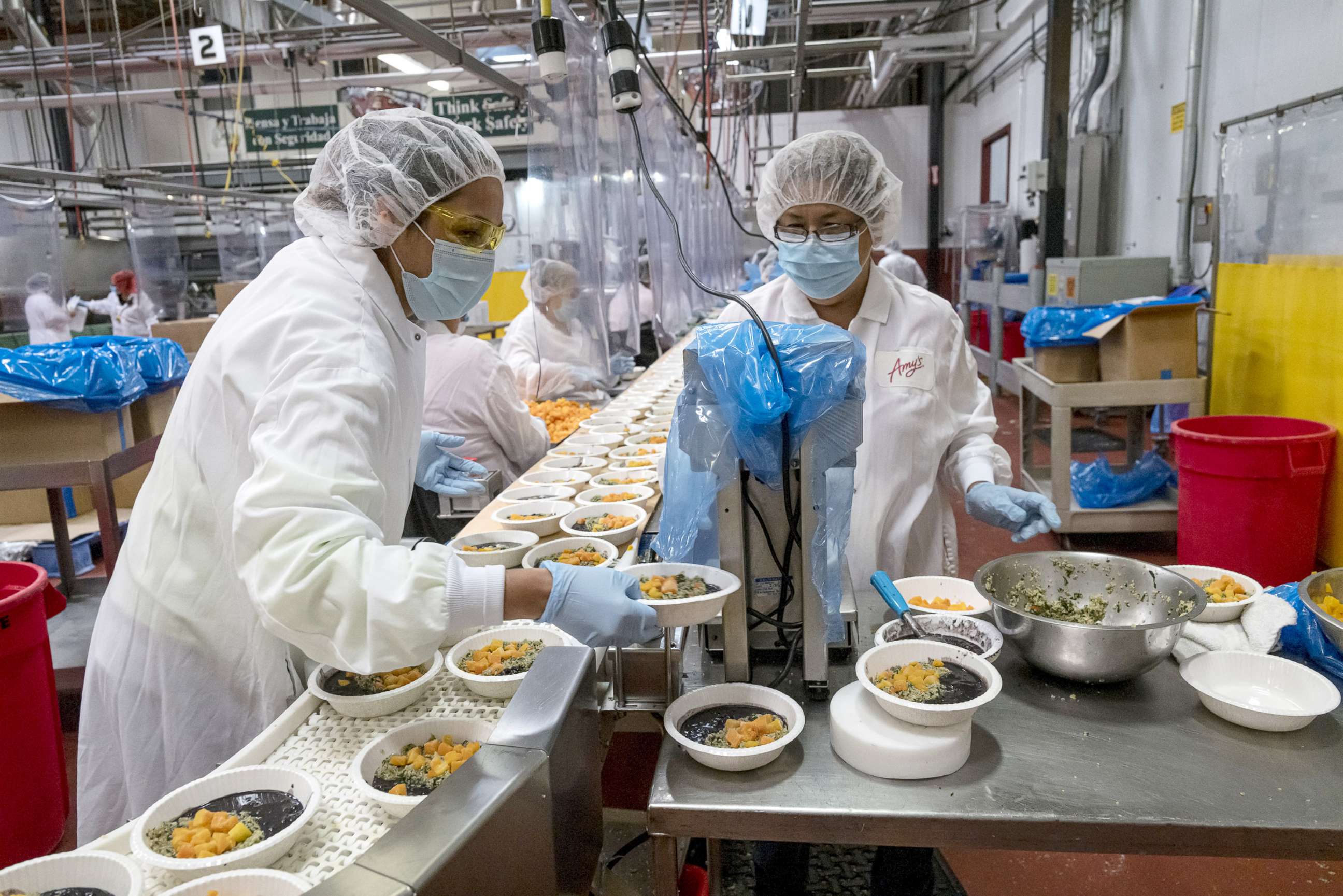 PHOTO: Workers wearing protective masks and food processing clothing perform quality checks at an Amy's Kitchen facility in Santa Rosa Calif., June 24, 2020.