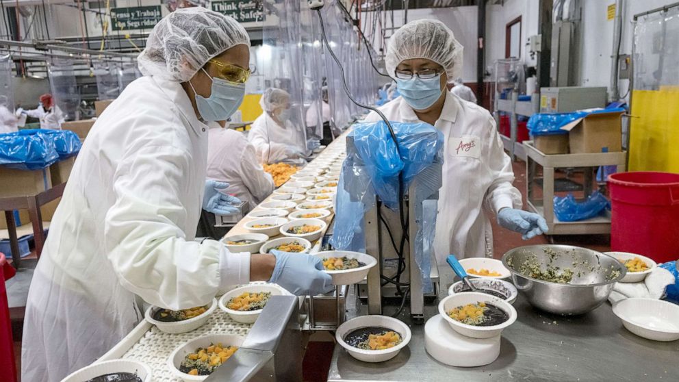 PHOTO: Workers wearing protective masks and food processing clothing perform quality checks at an Amy's Kitchen facility in Santa Rosa Calif., June 24, 2020.