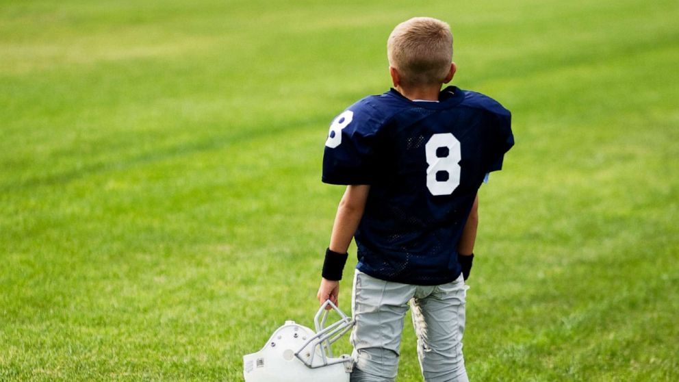 PHOTO: A boy stands in a football field.