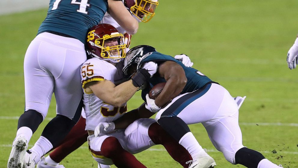 PHOTO: Linebacker Cole Holcomb of the Washington Football Team tackles running back Boston Scott of the Philadelphia Eagles during the first quarter of the game at Lincoln Financial Field on Jan. 03, 2021, in Philadelphia.