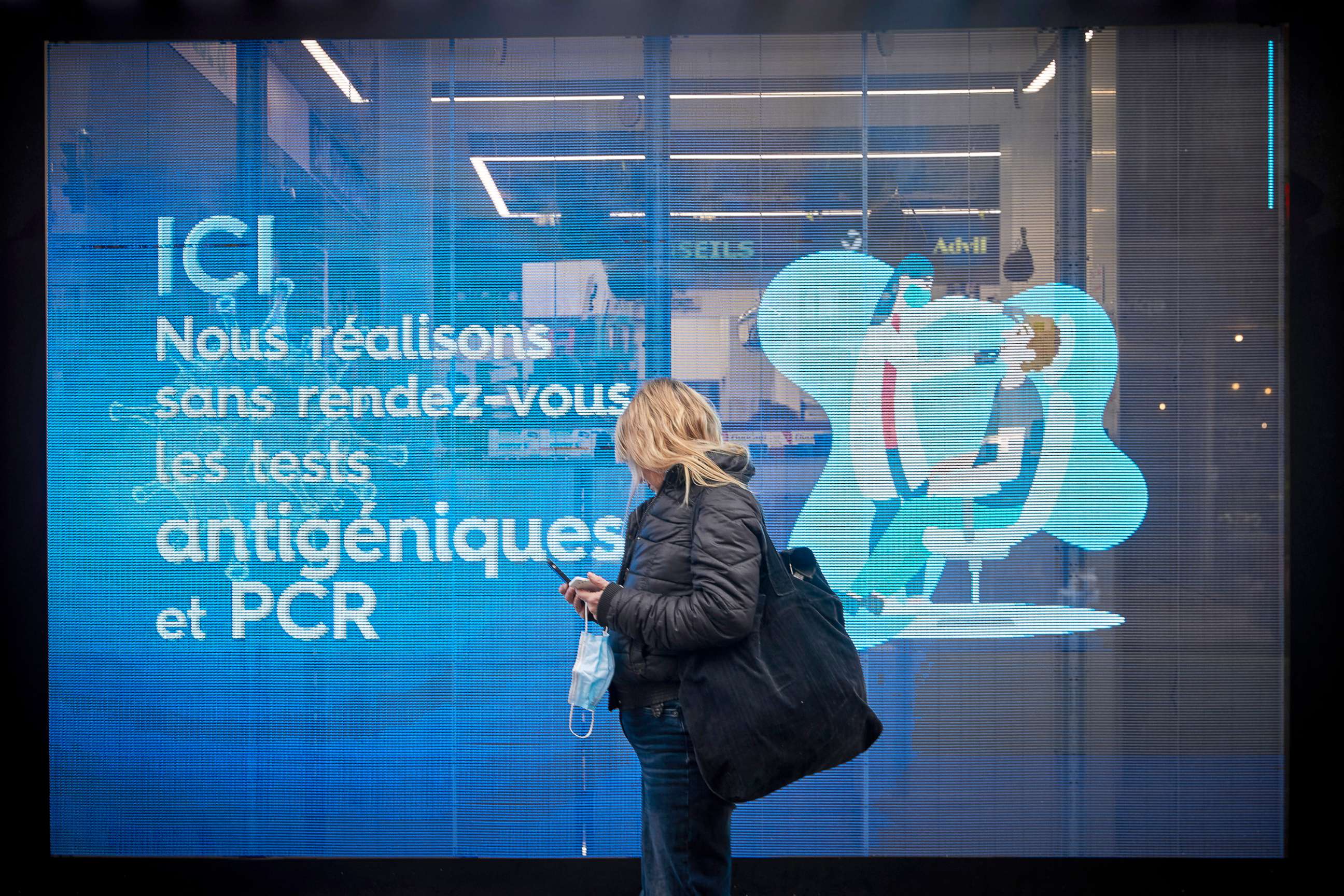 PHOTO: A person looks at a pharmacy window offering PCR and Antigen COVID-19 tests in Paris, Jan. 28, 2022.