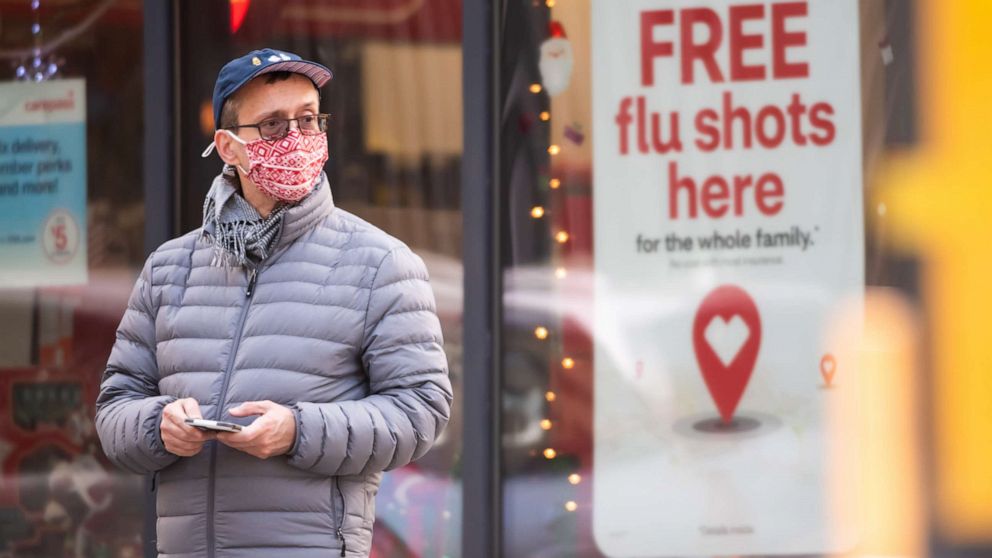 PHOTO: A person stands by a sign advertising flu shots at CVS as the city continues the reopening efforts following restrictions imposed to slow the spread of coronavirus on Dec. 1, 2020 in New York City.