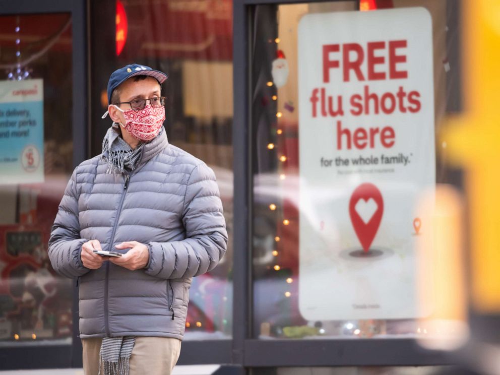 PHOTO: A person stands by a sign advertising flu shots at CVS as the city continues the reopening efforts following restrictions imposed to slow the spread of coronavirus on Dec. 1, 2020 in New York City.