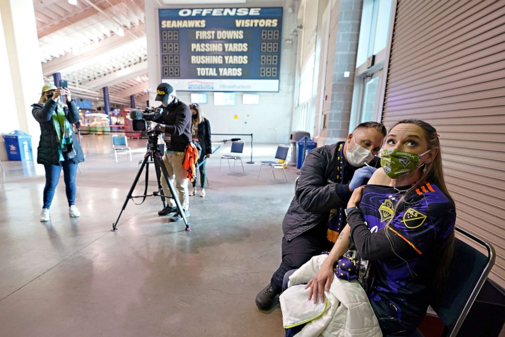 PHOTO: Stephanie Birman, right, a Seattle Sounders season ticket holder, gets the Johnson & Johnson COVID-19 vaccine at a clinic in a concourse at Lumen Field, May 2, 2021, prior to an MLS soccer match between the Sounders and the Los Angeles Galaxy.