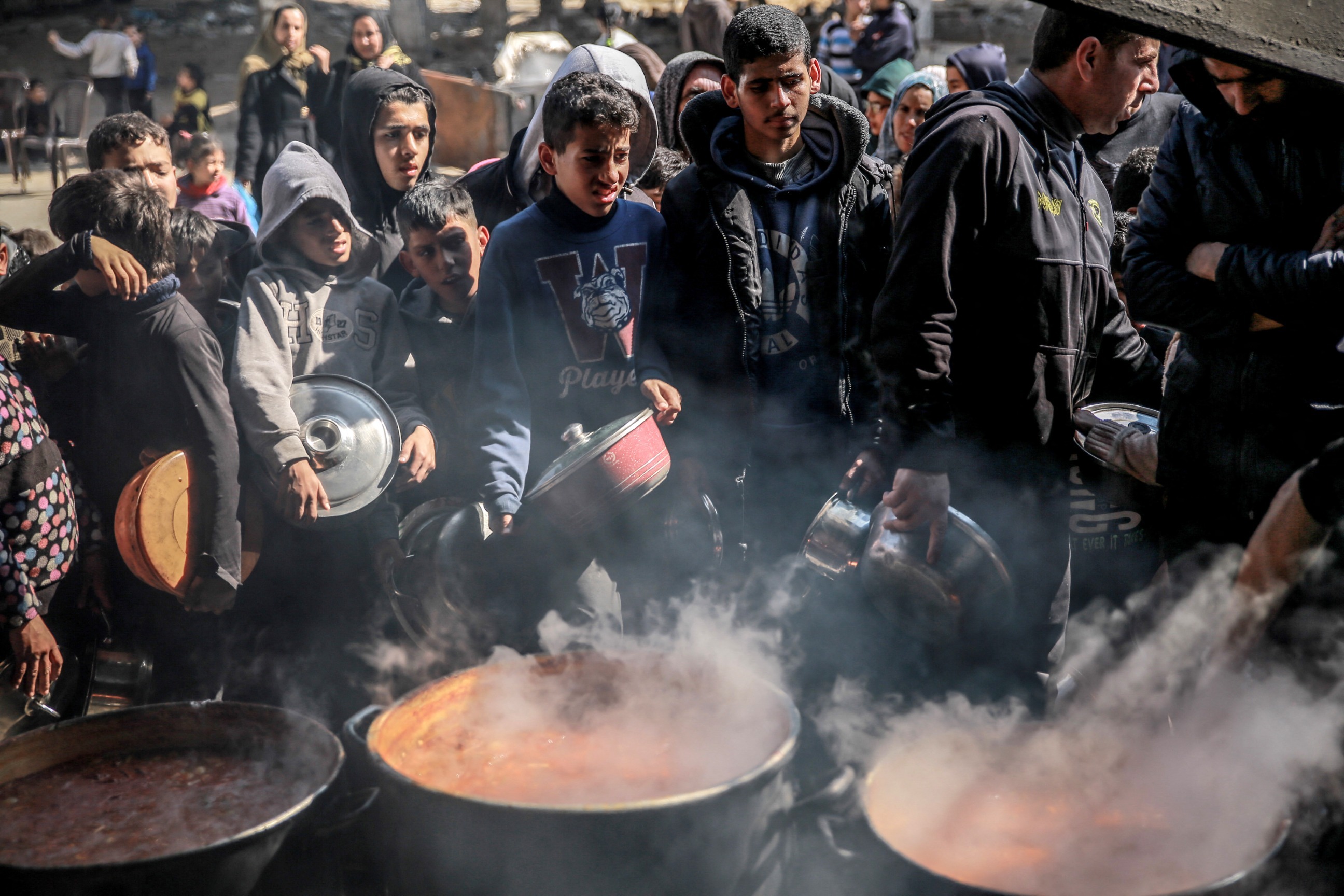 PHOTO: Palestinians gather to collect aid food in Beit Lahia, in the northern Gaza Strip, on February 26, 2024, amid continuing battles between Israel and the Palestinian militant group Hamas.