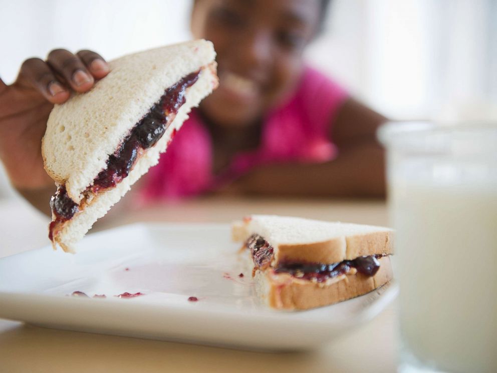 PHOTO: A girl picks up a peanut butter and jelly sandwich in an undated stock photo.