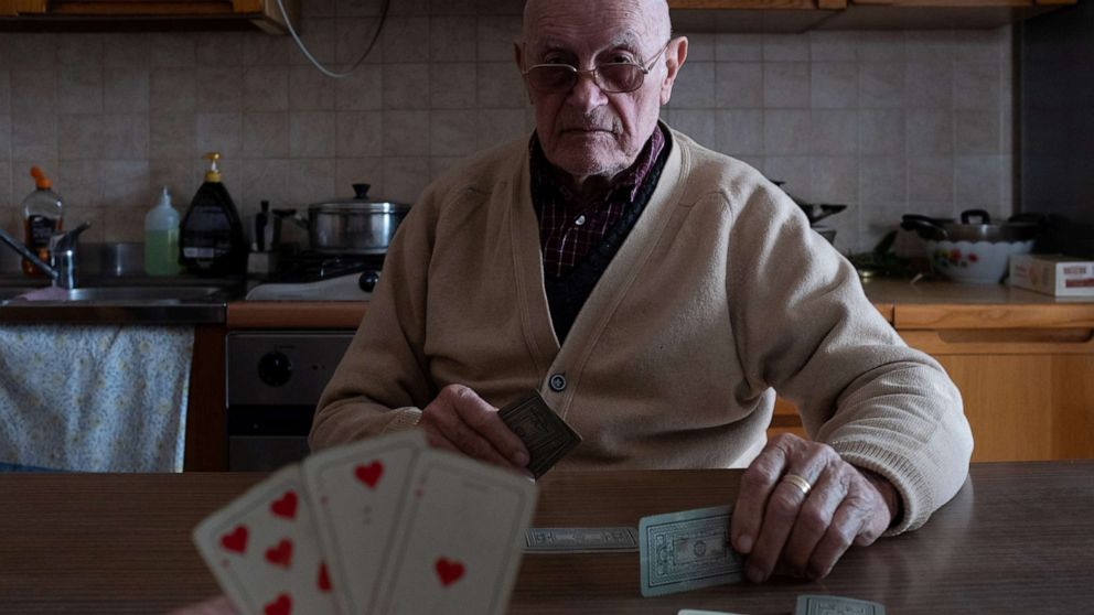 PHOTO: Marzio Toniolo, 35, and his grandfather, Gino Verani, 87, play a game of cards at home, during the coronavirus (COVID-19) outbreak, in San Fiorano, Italy, March 12, 2020.