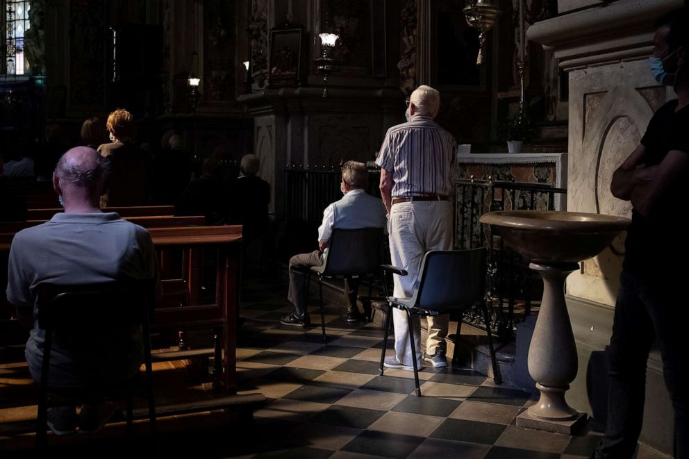PHOTO: Gianni, Gino Verani's friend, stands, after accidentally sitting on the chair that Verani used to always use during church services, during Gino Verani's funeral, during the coronavirus disease outbreak, in San Fiorano, Italy, Sept. 8, 2020.