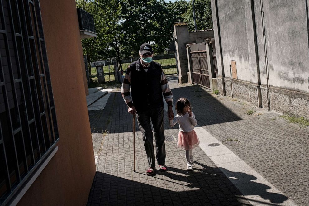 PHOTO: Gino Verani holds hands with his great-grand-daughter Bianca, 2, as they go on a walk together in San Fiorano, Italy, April 14, 2020.