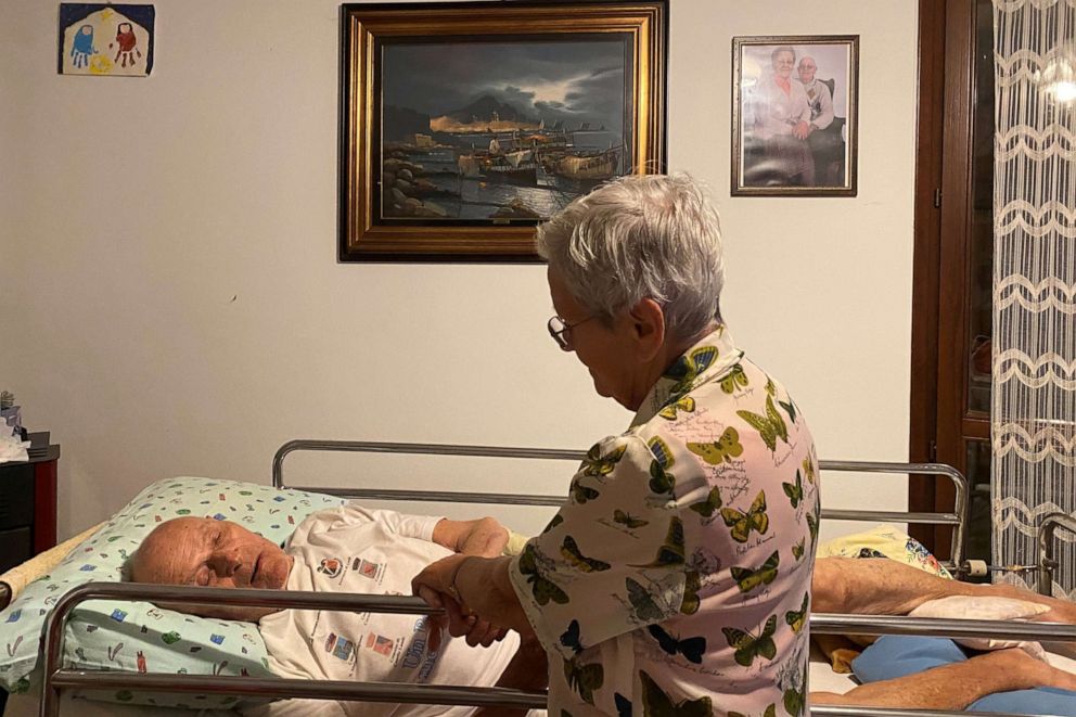 PHOTO: Gino Verani is comforted by his wife, Ines Prandini, at their home, during the coronavirus disease (COVID-19) outbreak, in San Fiorano, Italy, Aug. 30, 2020.