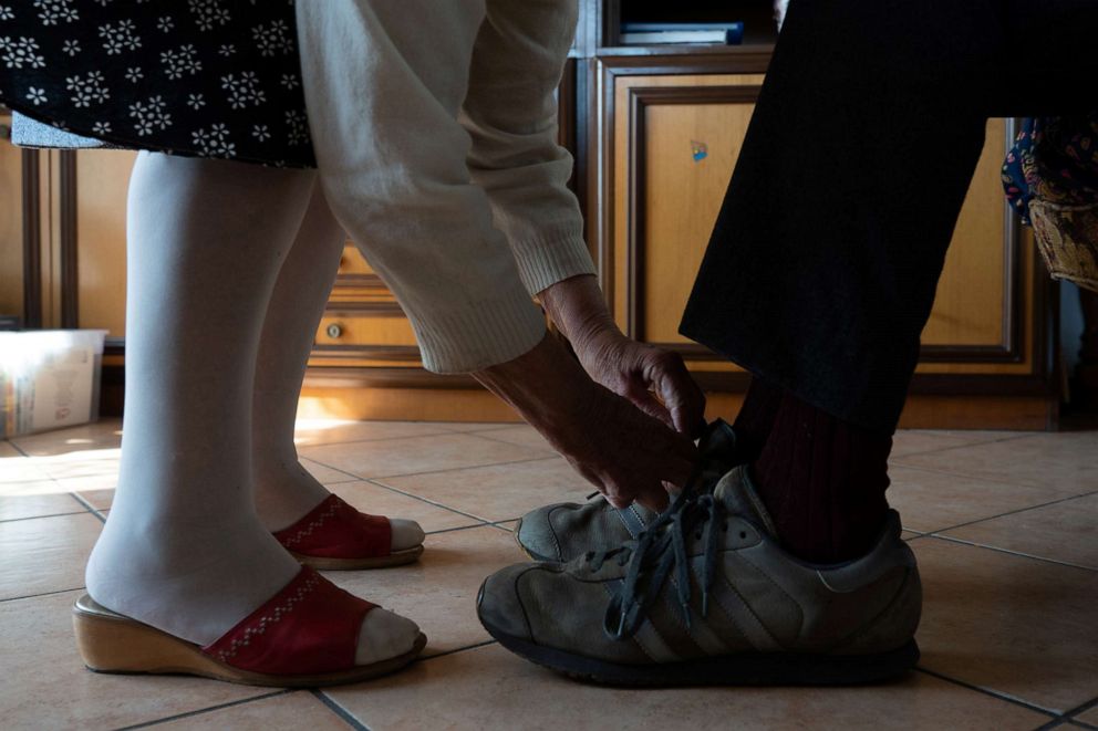 PHOTO: Ines Prandini, 85, ties her husband Gino Verani's, 87, shoelaces, at their home, during the coronavirus disease (COVID-19) outbreak, in San Fiorano, Italy, March 17, 2020.