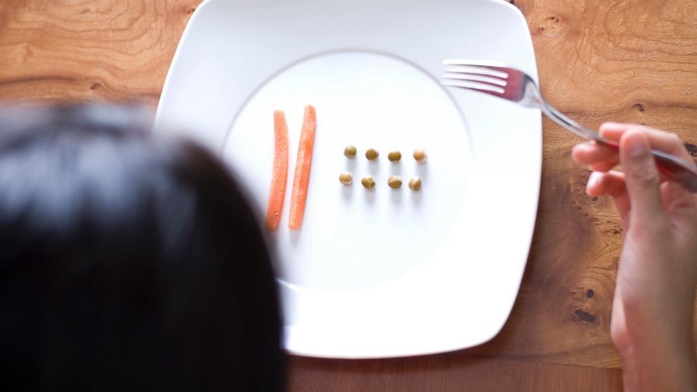 A women looks at food on a plate. 