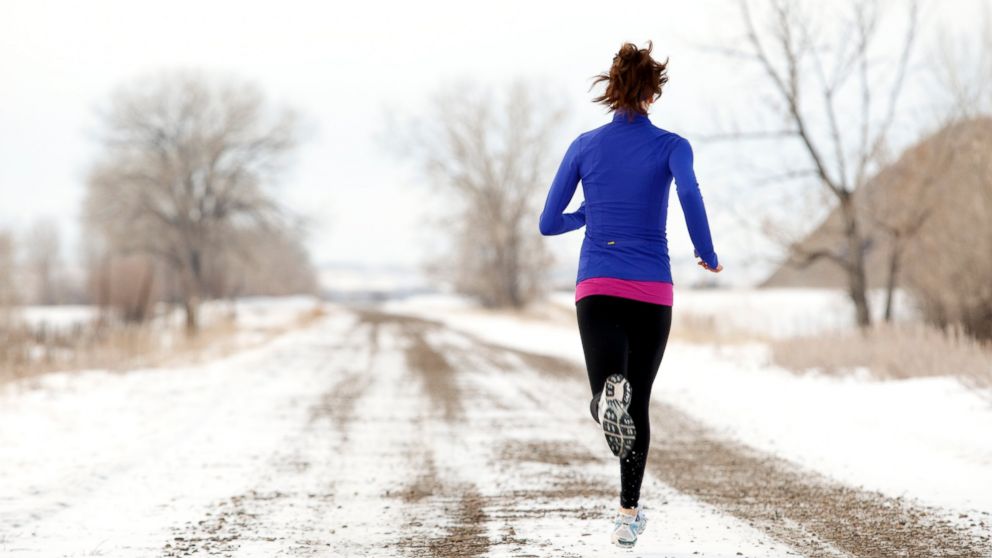 A woman is seen jogging in winter in this stock photo.