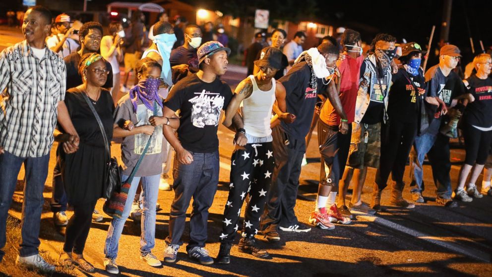 PHOTO: Demonstrators protest the shooting death of teenager Michael Brown on August 13, 2014 in Ferguson, Missouri.