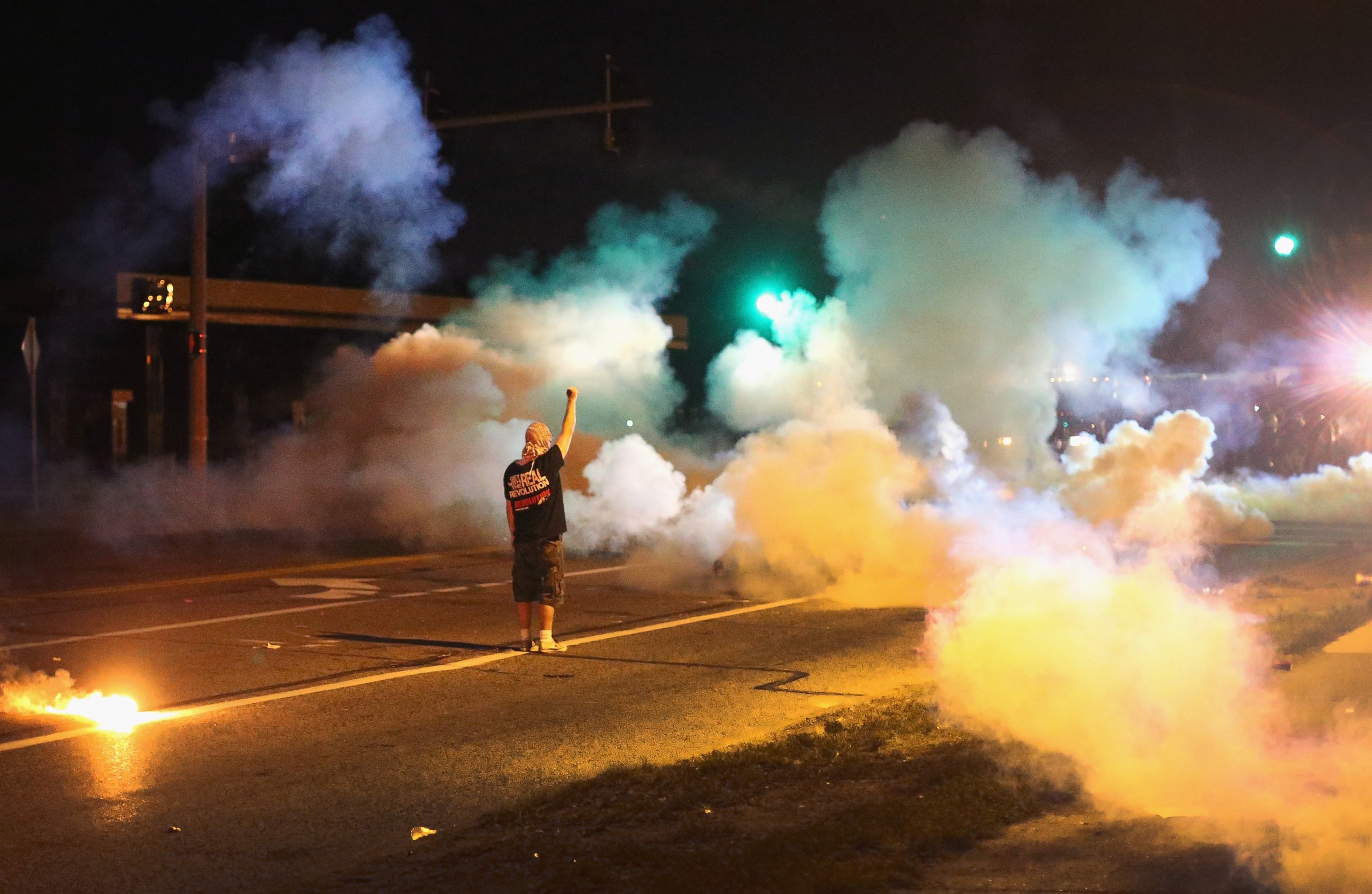PHOTO: A demonstrator, protesting the shooting death of teenager Michael Brown, stands his ground as police fire tear gas on August 13, 2014 in Ferguson, Missouri. 