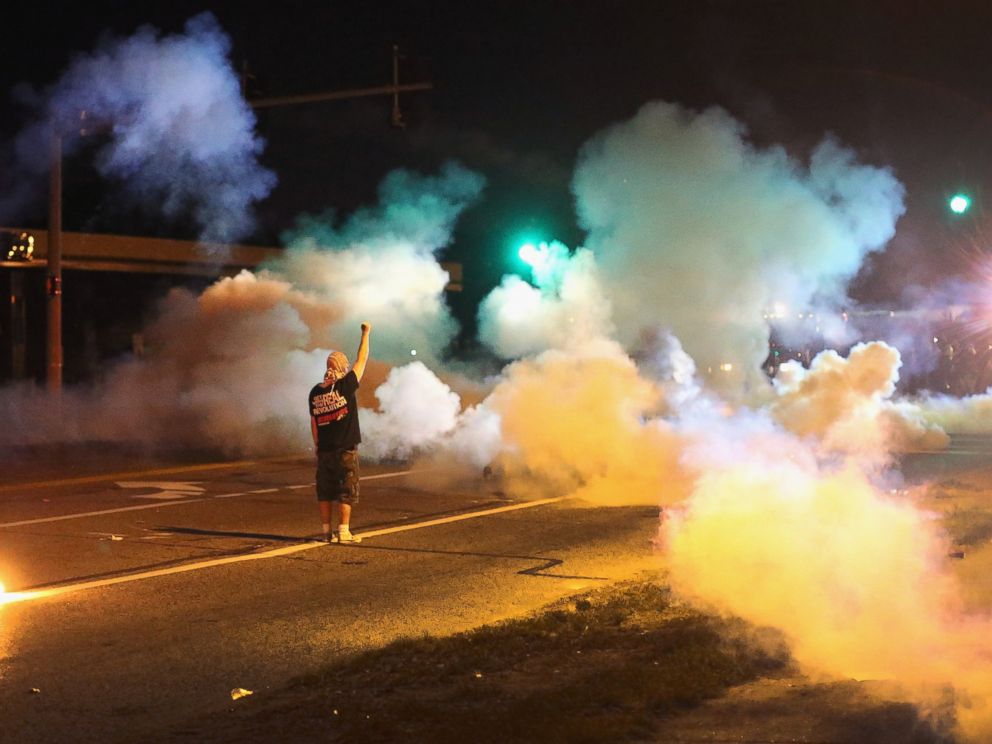 PHOTO: A demonstrator, protesting the shooting death of teenager Michael Brown, stands his ground as police fire tear gas on August 13, 2014 in Ferguson, Missouri.
