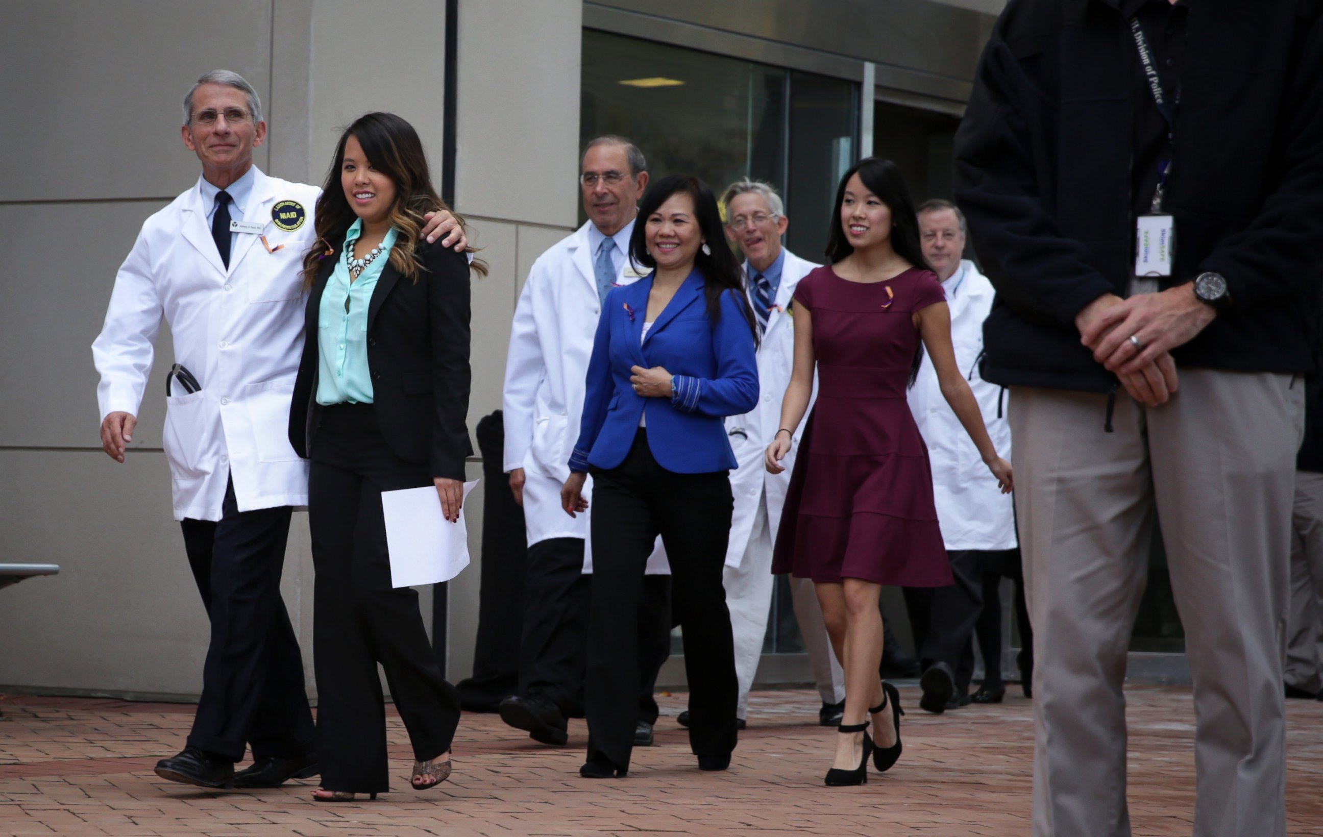 PHOTO: Director of the National Institute of Allergy and Infectious Diseases Anthony Fauci comes out of the building with Nina Pham for a news briefing at National Institutes of Health on Oct. 24, 2014 in Bethesda, Md.