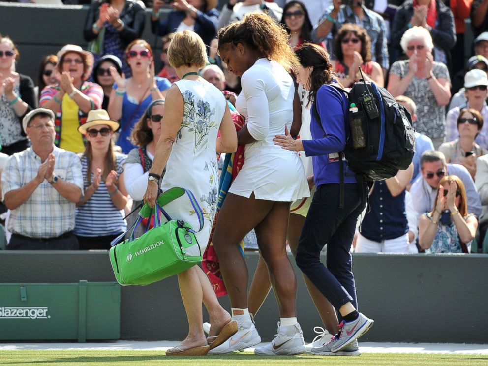 PHOTO: Serena Williams and her sister Venus Williams leave the court after retiring from their womens doubles match after Serena was taken ill during the 2014 Wimbledon Championships in Wimbledon, southwest London, on July 1, 2014.