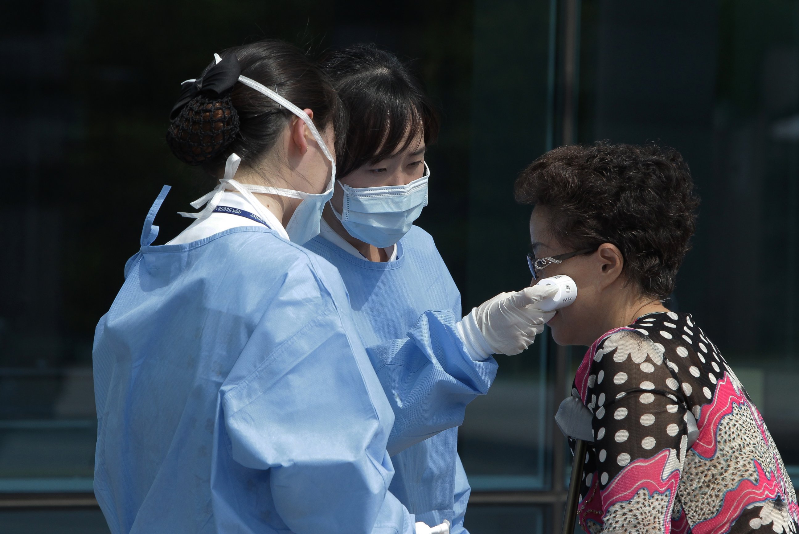 PHOTO: Medical staffs check the temperature of a visitor at Seoul Medical Center where eight MERS patients are hospitalized on June 10, 2015 in Seoul, South Korea. 