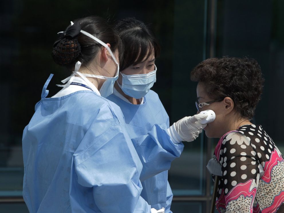 PHOTO: Medical staffs check the temperature of a visitor at Seoul Medical Center where eight MERS patients are hospitalized on June 10, 2015 in Seoul, South Korea.