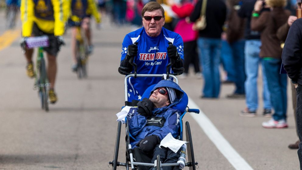 PHOTO: Dick Hoyt pushes his son, Rick Hoyt, in a specialized wheelchair during the 117th Boston Marathon on April 15, 2013.