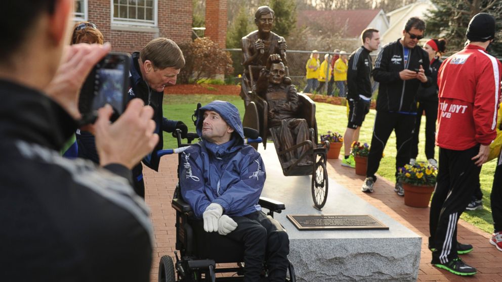 PHOTO: Dick Hoyt,  left, and his son, Rick, pose for photos by their statue at the start of the Boston Marathon in Hopkinton, Mass., on April 15, 2013.
