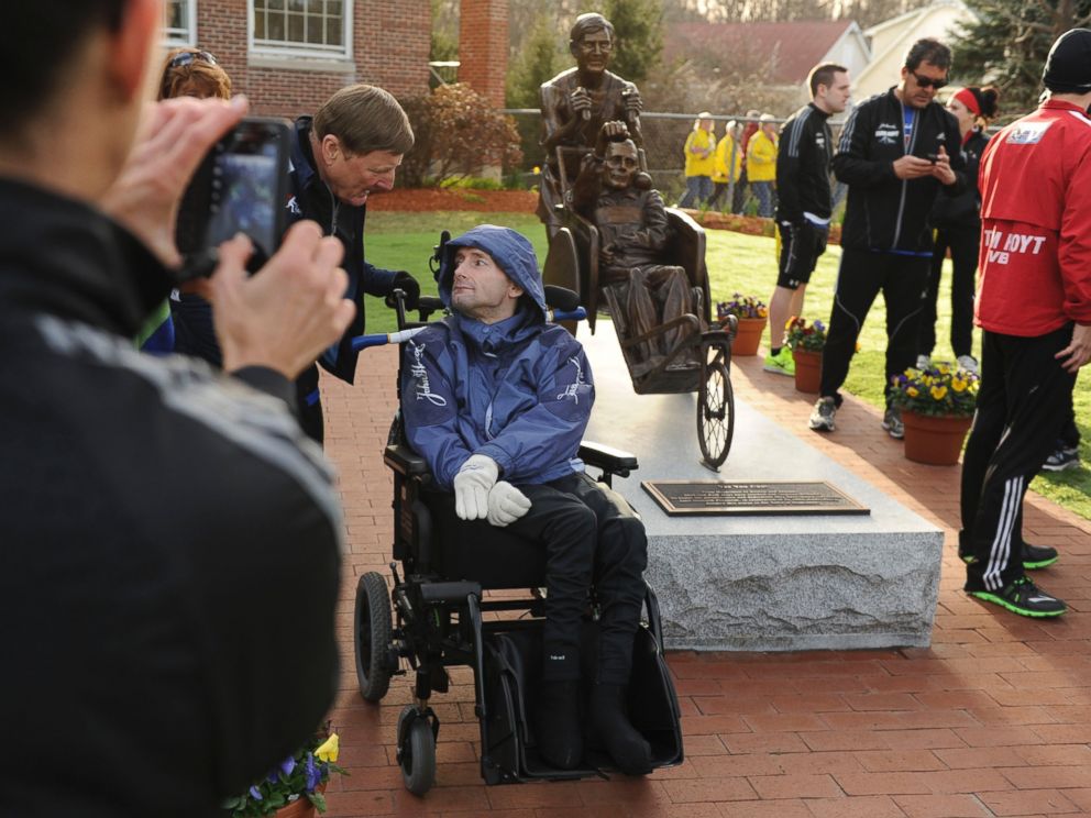 PHOTO: Dick Hoyt,  left, and his son, Rick, pose for photos by their statue at the start of the Boston Marathon in Hopkinton, Mass., on April 15, 2013.