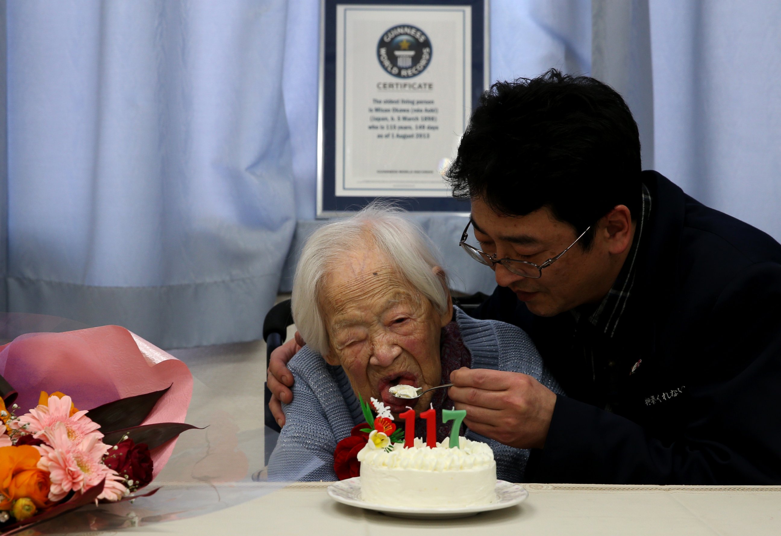 PHOTO: A nursing home employee helps Misao Okawa, who is recognised by Guinness World Records as the world's oldest living person, eat her birthday cake on her 117th birthday celebration at Kurenai Nursing Home on March 5, 2015 in Osaka, Japan.