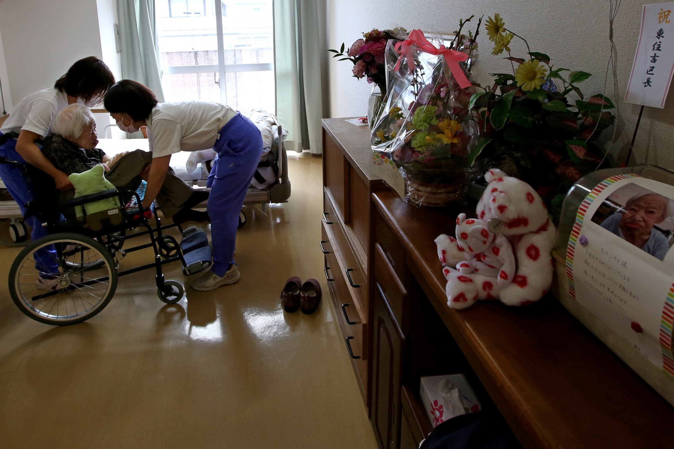 PHOTO: Nursing home staff help Misao Okawa, the world's oldest Japanese woman, get into bed after lunch on her 117th birthday at Kurenai Nursing Home on March 5, 2015 in Osaka, Japan.