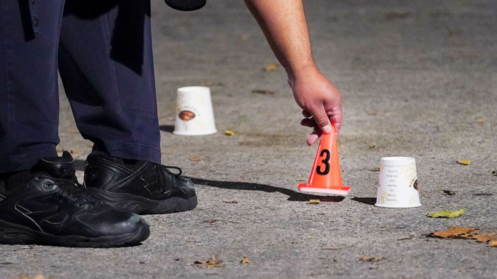 PHOTO: A bullet casing is marked by a New York City Police Department officer at a crime scene where several young men were shot in the Queens borough of New York, Aug.18, 2020.