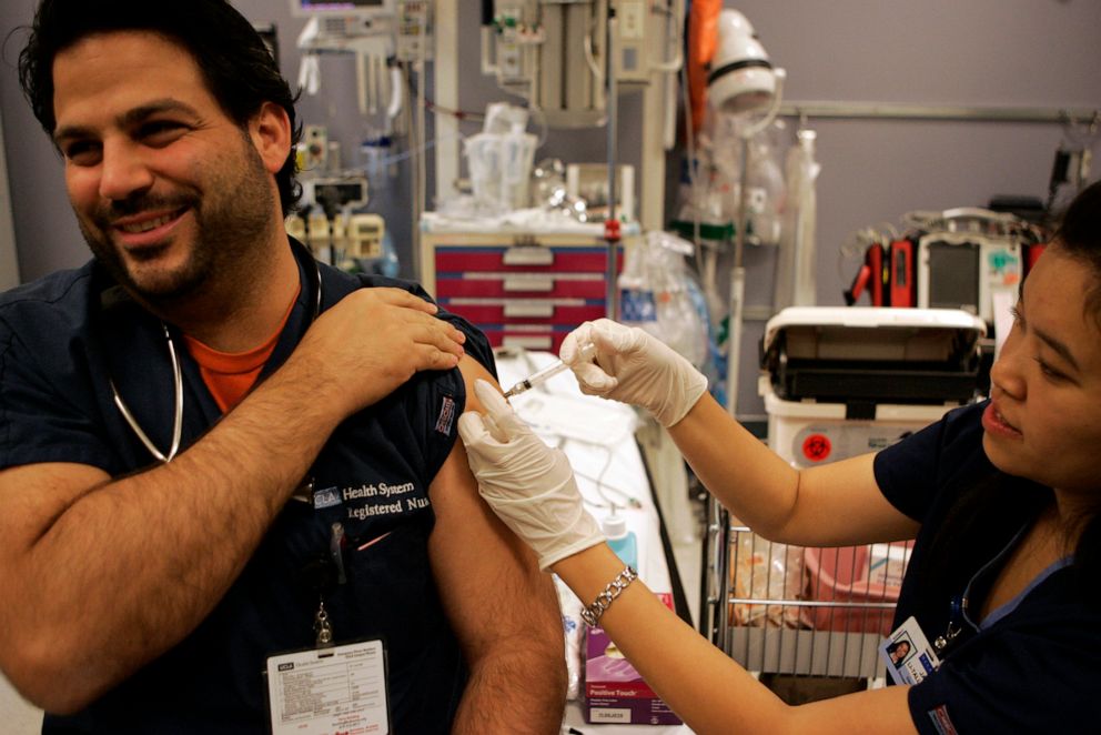 PHOTO: Nurse Janet LiTall administers the H1N1 flu shot to Emergency Room nurse Romeo Spina in a trauma room at Ronald Reagan Medical Center, UCLA, on Oct. 30, 2009, in Los Angeles.