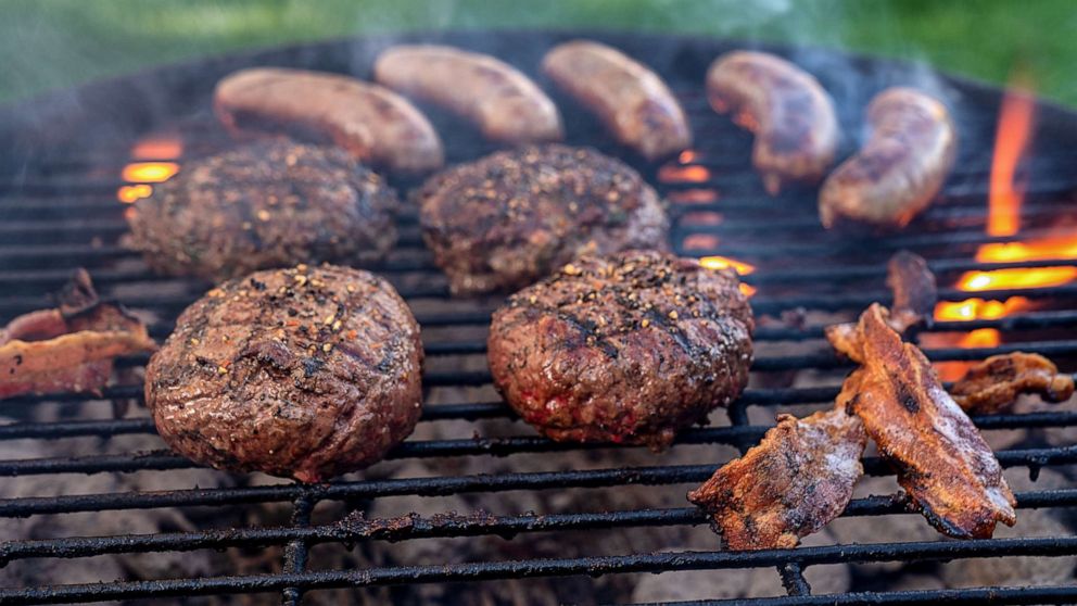 PHOTO: Cheeseburgers and Brats on a Fiery Charcoal Grill with Flames