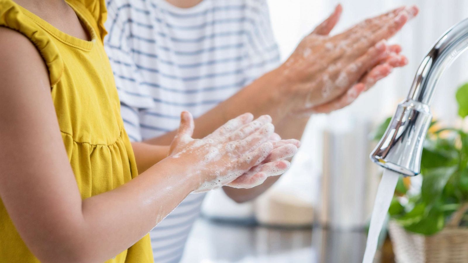 PHOTO: A mother and daughter wash their hands together.