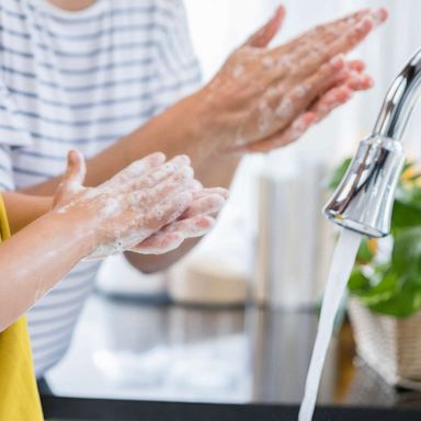 PHOTO: A mother and daughter wash their hands together.