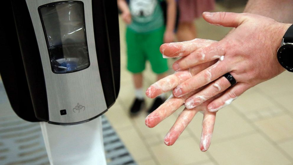 PHOTO: A traveller uses hand sanitizer from a dispenser at Sky Harbor Airport in Phoenix, March 17, 2020.