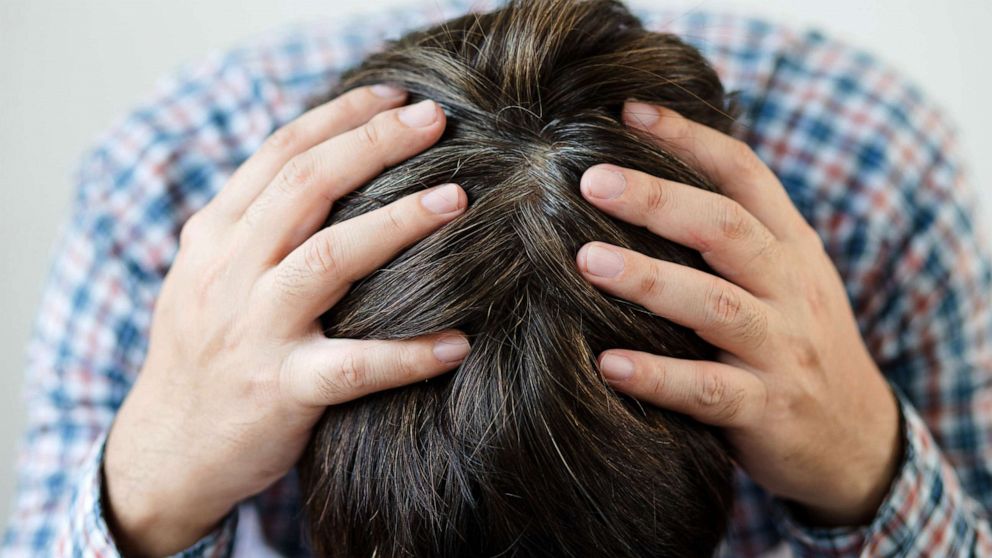 PHOTO: Stock photo of a person holding their head.