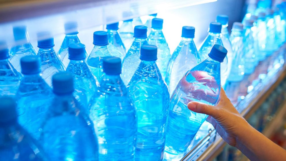 PHOTO: Someone takes a bottle of water from a shelf in an undated stock photo.