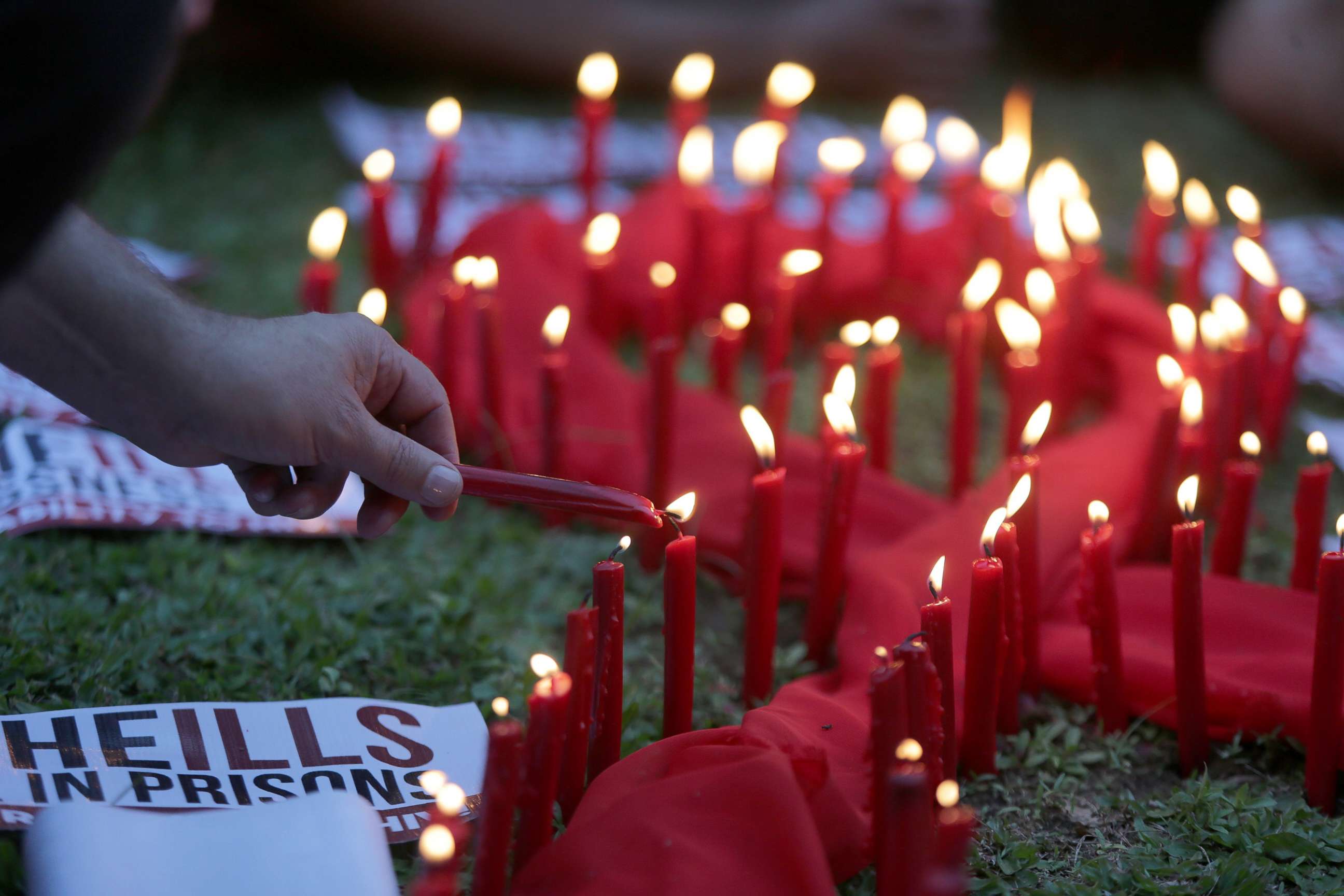 PHOTO: A man lights candles on a red ribbon shaped cloth in observance of the World AIDS Day in Quezon City, the Philippines, Dec. 1, 2016.