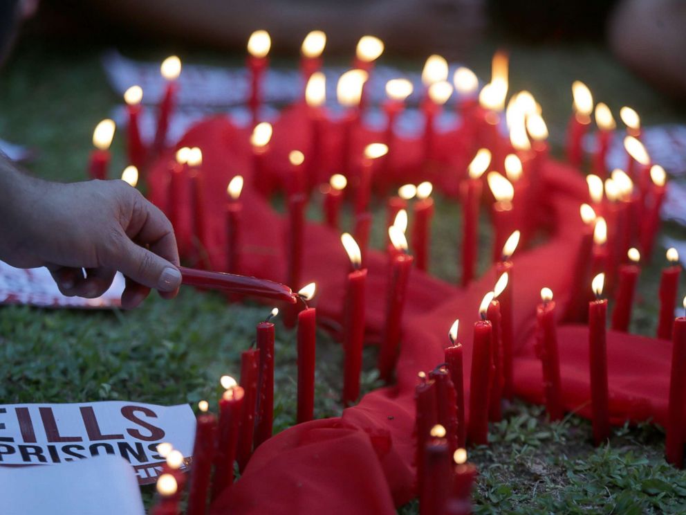 PHOTO: A man lights candles on a red ribbon shaped cloth in observance of the World AIDS Day in Quezon City, the Philippines, Dec. 1, 2016.