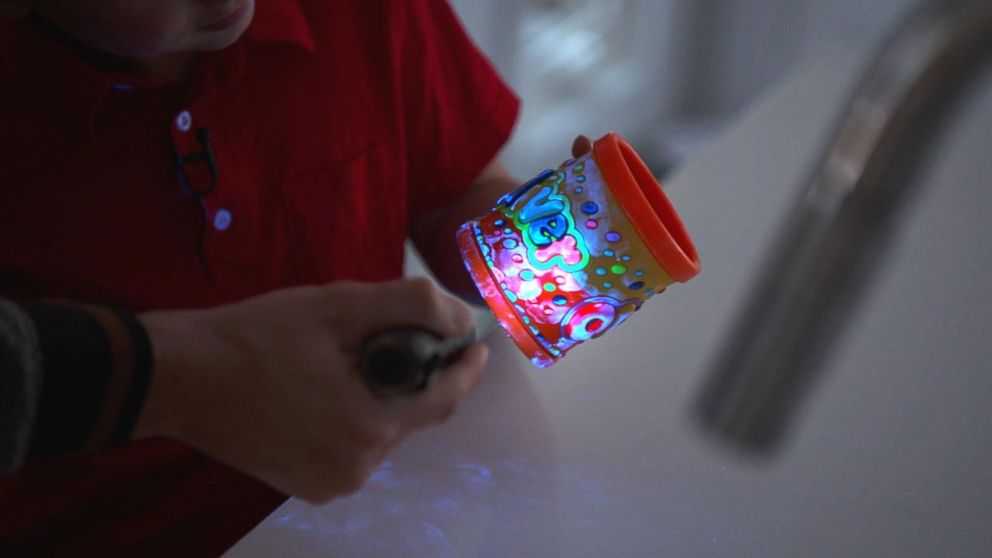 PHOTO: A special UV light shows germs on a cup.