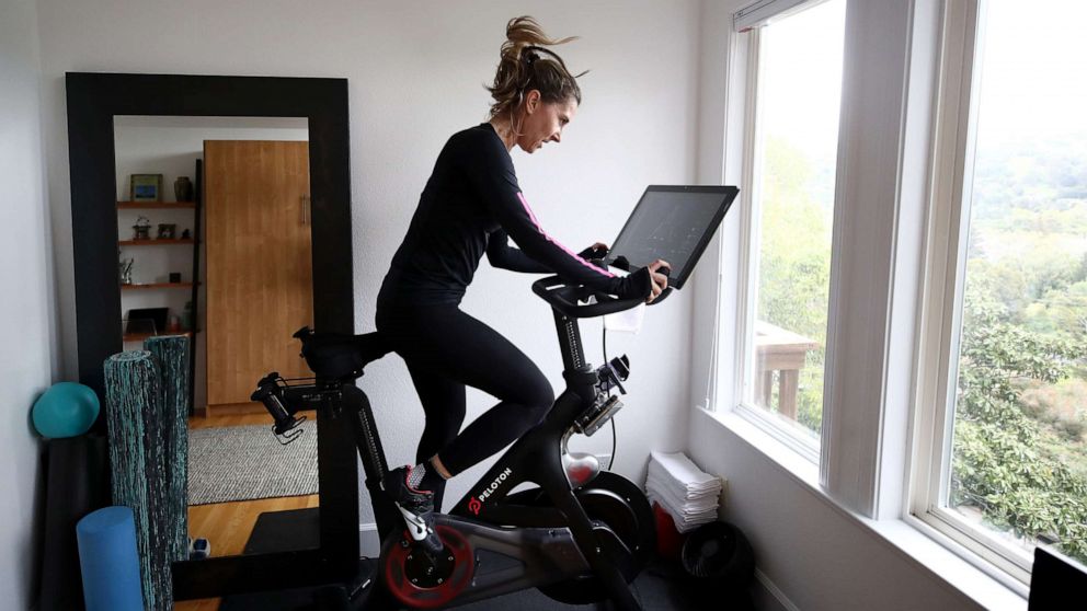 PHOTO: Cari Gundee rides her Peloton exercise bike at her home, April 6, 2020, in San Anselmo, California.