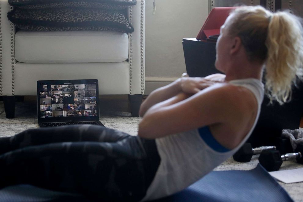 PHOTO: Shane Barnard, CEO of UrbanKick, looks toward participants on her computer in the HIIT and Core class she taught from her home in Oakland, Calif., March 26, 2020.