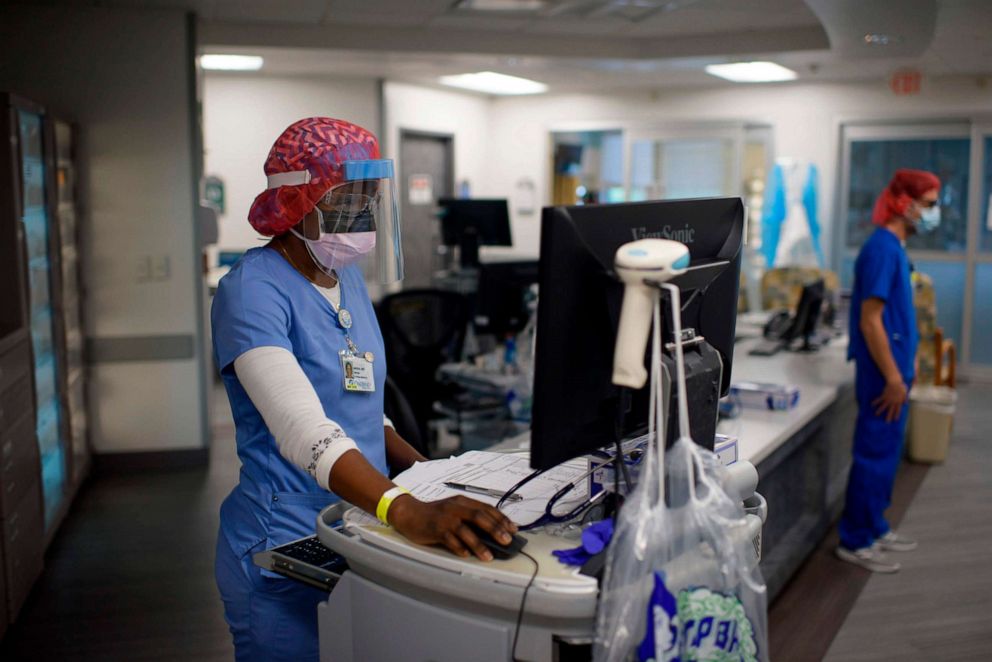 PHOTO: Registered Respiratory Therapist Niticia Mpanga looks through patient information in the ICU at Oakbend Medical Center in Richmond, Texas, on July 15, 2020.