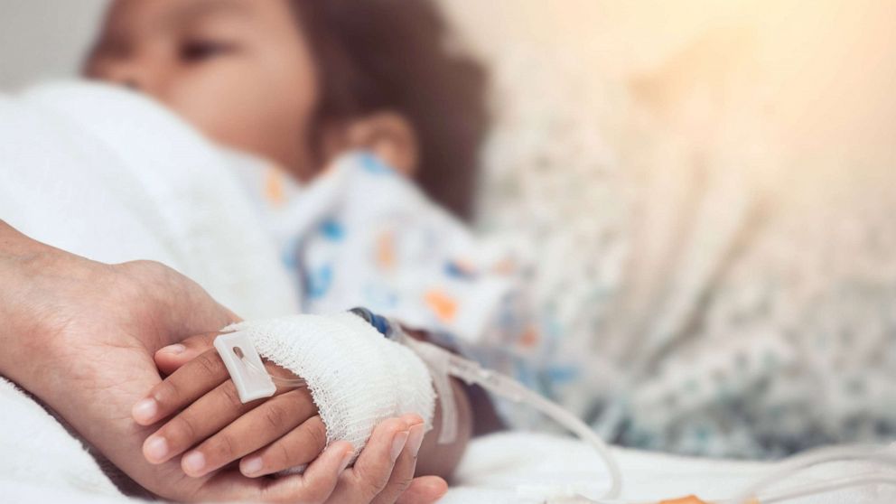 PHOTO: A mother holds her child's hand while she is hospitalized, in a stock image.