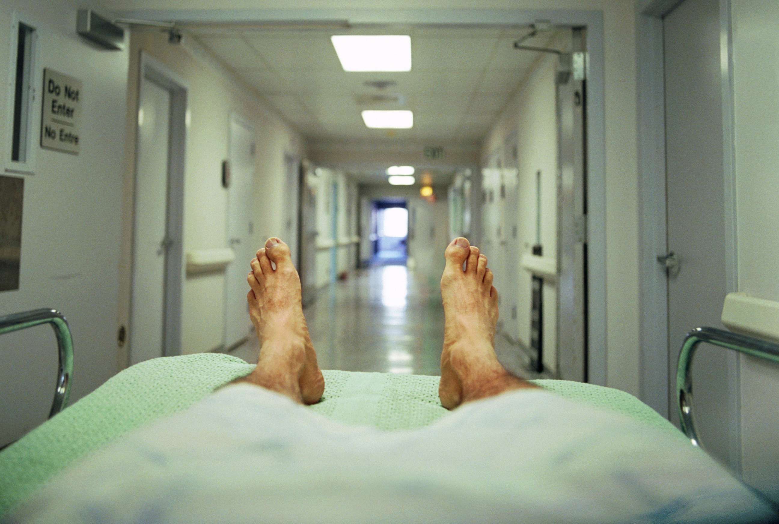 PHOTO: A person lays on a gurney in a hospital corridor in this stock photo.