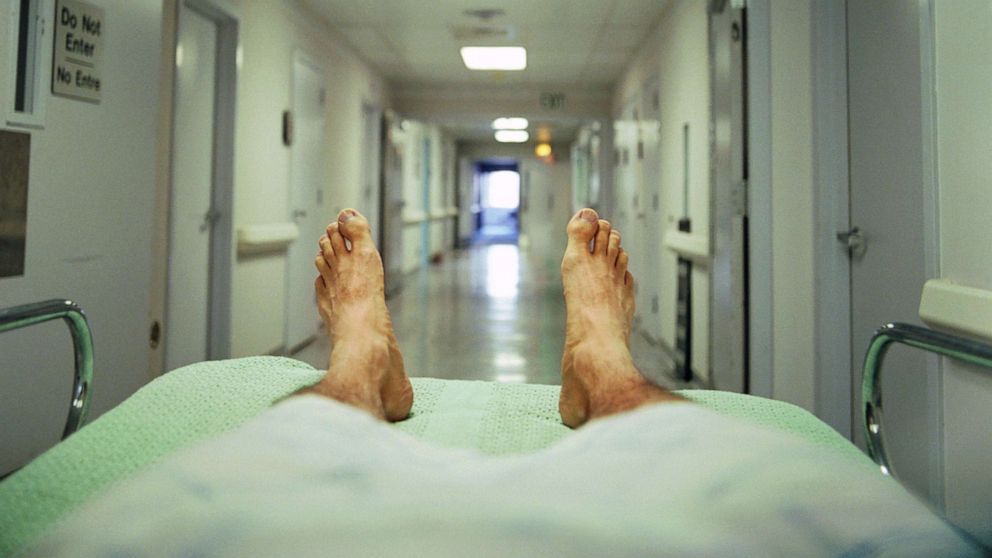 PHOTO: A person lays on a gurney in a hospital corridor in this stock photo.