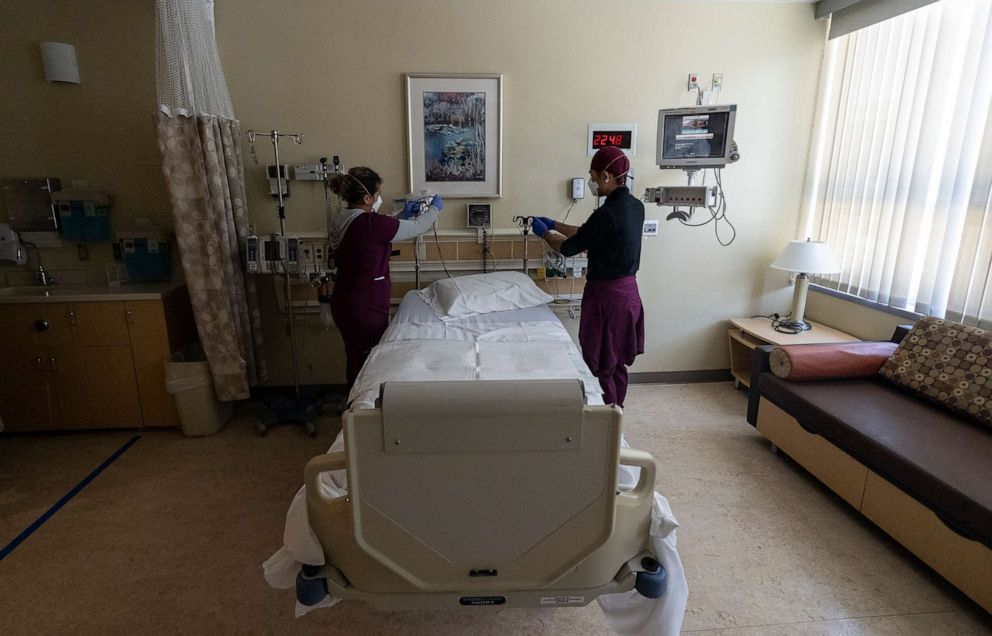 PHOTO: In this April 14, 2022, file photo, nurse assistants prepare a room at Providence St. Joseph Hospital, in Orange, Calif.