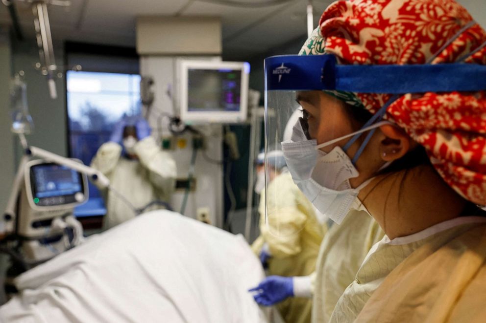 PHOTO: Sammy Taylor, a registered nurse at Western Reserve Hospital, works with other medical staff treating a COVID-19 patient in their isolation room on the Intensive Care Unit (ICU) at Western Reserve Hospital in Cuyahoga Falls, Ohio, Jan. 4, 2022. 