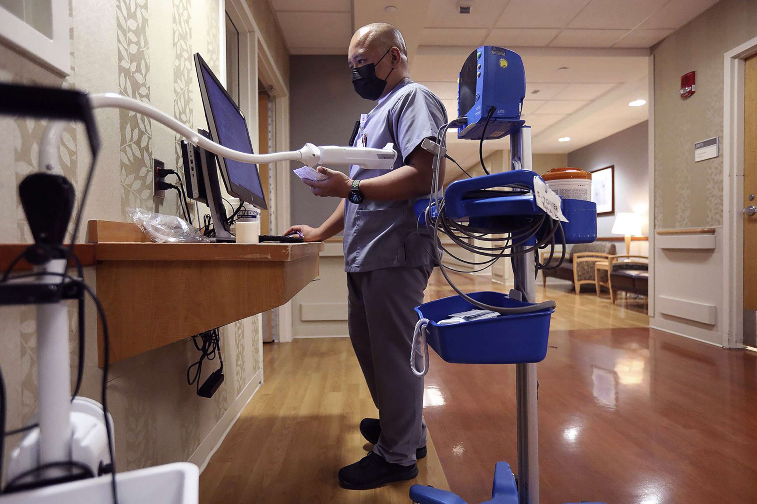 PHOTO: Patient care technician Eimann Joseph Mago checks vitals and orders on a computer at Loyola University Medical Center in Maywood, Ill., April 22, 2022.